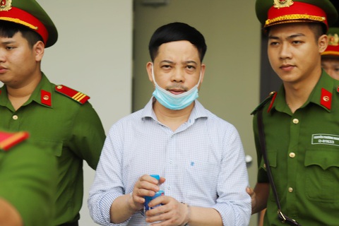 Cựu thư ký thứ trưởng nói ‘từng ám ảnh chỉ muốn chết để thoát khỏi áp lực’ - Ảnh 1. Cựu thư ký thứ trưởng Bộ Y tế được dẫn giải đến phiên tòa "chuyến bay giải cứu" - Ảnh: DANH TRỌNG