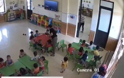 Nghi vấn học sinh mầm non bị cô giáo tát vào người, kéo lê dưới nền gạch vào phòng đánh tới tấp - Ảnh 2. Sau khi kéo lê vào phòng bên cạnh, cô giáo tiếp tục đánh tới tấp vào người cháu bé - Ảnh cắt từ clip