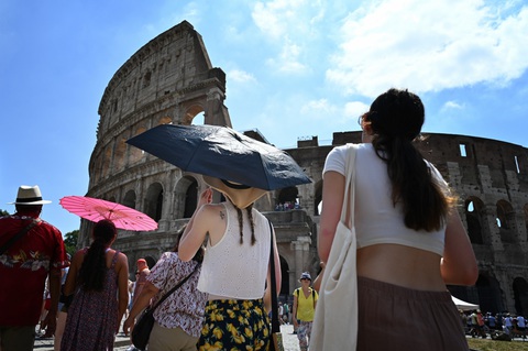Du khách đi tham quan dưới nắng nóng ở Rome ngày 14-7 - Ảnh: AFP Du khách đi tham quan dưới nắng nóng ở Rome ngày 14-7 - Ảnh: AFP