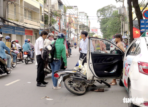 Ớn lạnh khi cửa xe ô tô thình lình bật mở - Ảnh 1. Lái xe taxi mở cửa bên trái không quan sát gây tai nạn cho người đi xe máy cùng chiều - Ảnh minh họa: T.T.D.