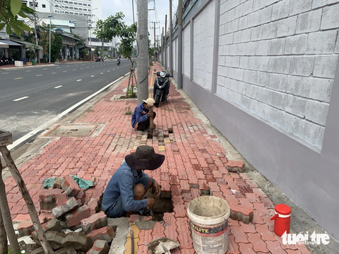 Vìa hè đường Lê Văn Chí bị xói lở, chủ đầu tư nói do mưa và ngầm hóa điện - Ảnh 7. Chiều 15-7, các công nhân sửa chữa vỉa hè bị xói lở - Ảnh: Ban quản lý dự án đầu tư xây dựng khu vực TP Thủ Đức