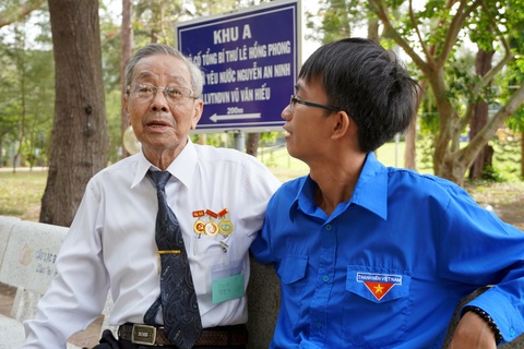 Lễ kỷ niệm 76 năm ngày Thương binh liệt sĩ tại Côn Đảo rất đặc biệt, ý nghĩa - Ảnh 3. Một cựu tù chính trị Côn Đảo trò chuyện với thế hệ trẻ tại nghĩa trang Hàng Dương, Côn Đảo - Ảnh: Đ.H.
