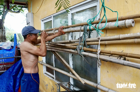 Bão số 1: Hải Phòng, Quảng Ninh đưa hơn 10.000 khách về bờ, người dân chằng chéo hàng quán - Ảnh 3. Người dân tại bãi tắm khu 1 quận Đồ Sơn, TP Hải Phòng gia cố nhà cửa - Ảnh: TIẾN THẮNG