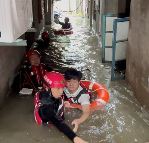 - Ảnh 3. Lực lượng cứu hộ giải cứu người dân mắc kẹt do lũ ở Phúc Châu - Ảnh: REUTERS