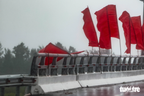 Bão số 1 vẫn trên đất liền Trung Quốc, miền Bắc còn mưa to - Ảnh 6. Gió bão làm gãy cờ treo trên một cây cầu ở thành phố Móng Cái - Ảnh: NGUYỄN KHÁNH