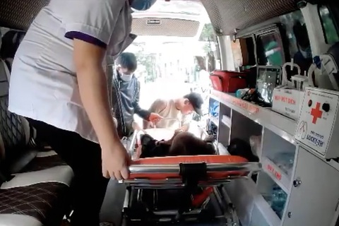 Chấm dứt hợp đồng 3 bảo vệ làm khó xe chở bệnh thiện nguyện - Ảnh 1. Bà N.T.H. được đưa lên xe cấp cứu, bên ngoài bảo vệ tranh cãi với người nhà bệnh nhân - Ảnh: V.P.