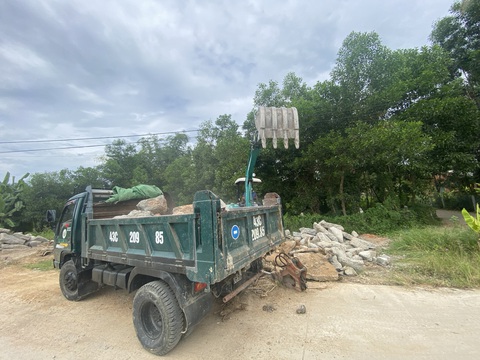 Chủ đầu tư đường bê tông ở Đà Nẵng nói đường kém chất lượng là do dân tự tháo rào chắn - Ảnh 3. Nhà thầu huy động máy cơ giới dọn dẹp lề đường sáng 18-7 - Ảnh: B.D.