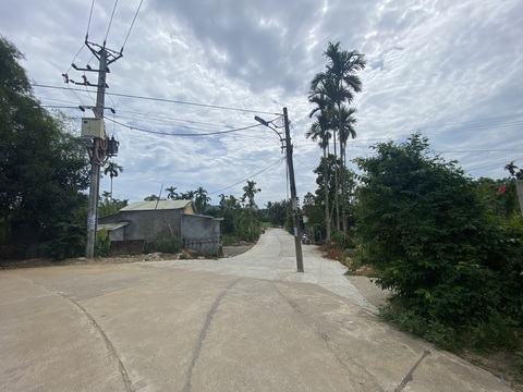 Chủ đầu tư đường bê tông ở Đà Nẵng nói đường kém chất lượng là do dân tự tháo rào chắn - Ảnh 5. Trụ điện nằm trong lòng đường bê tông đoạn qua thôn Trước Đông cũng được di dời từ sáng 18-7 - Ảnh: B.D.