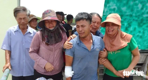 Cứu bốn ngư dân trên tàu chìm ra khơi sau bão số 1 - Ảnh 1. Ngư dân thoát nạn sau sự cố chìm tàu vào bờ trong vòng tay người thân trưa 19-7 - Ảnh: N.THẮNG
