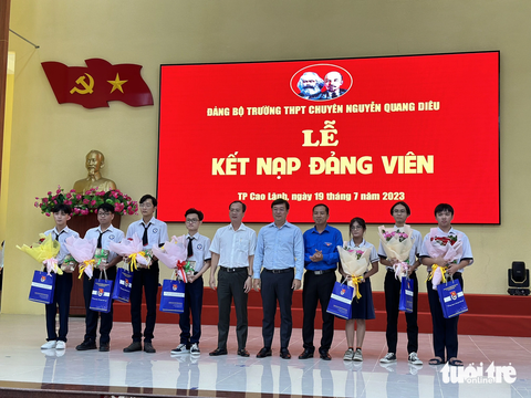 Kết nạp đảng cho bảy học sinh trường chuyên siêng làm nông nghiệp hữu cơ - Ảnh 1. Ông Lê Quốc Phong - bí thư Tỉnh ủy Đồng Tháp (thứ 5 từ phải) - tặng hoa chúc mừng các đảng viên học sinh ưu tú - Ảnh: ĐẶNG TUYẾT