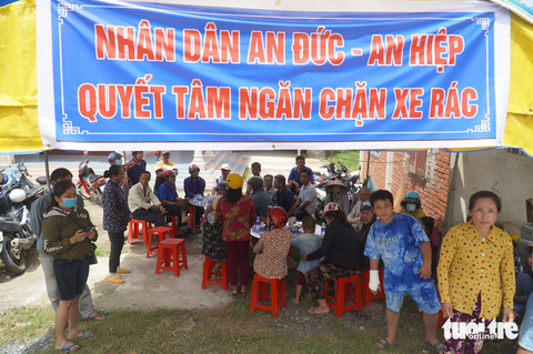Người dân treo băng rôn chặn xe chở rác vì không chịu nổi ô nhiễm - Ảnh 1. Rất đông người dân treo băng rôn phản đối bãi rác gây ô nhiễm môi trường và chặn không cho xe chở rác vào bãi - Ảnh: MẬU TRƯỜNG