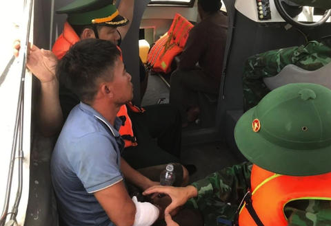 Cứu bốn ngư dân trên tàu chìm ra khơi sau bão số 1 - Ảnh 3. Các chiến sĩ biên phòng sơ cứu cho ngư dân bị thương - Ảnh: N.THẮNG