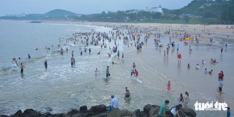 Hễ cuối tuần, du lịch Phan Thiết - Mũi Né “cháy phòng” - Ảnh 1. Du khách vui chơi, tắm biển tấp nập tại bãi Đá Ông Địa, TP Phan Thiết, Bình Thuận - Ảnh: ĐỨC TRONG