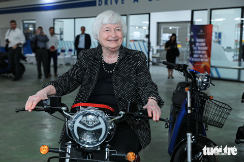 Bộ trưởng Tài chính Mỹ thử xe máy điện của startup Việt Nam - Ảnh 1. Bộ trưởng Yellen thích thú khi ngồi thử xe máy điện do doanh nghiệp Việt Nam sản xuất, lắp ráp - Ảnh: DANH KHANG