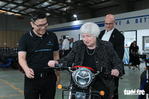 Bộ trưởng Tài chính Mỹ thử xe máy điện của startup Việt Nam - Ảnh 4. Bộ trưởng Yellen thích thú khi ngồi thử xe máy điện - Ảnh: DANH KHANG