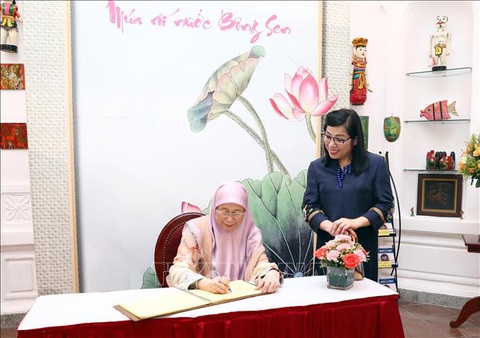 Hai Phu nhân Thủ tướng Việt Nam và Malaysia cùng thưởng thức múa rối nước - Ảnh 6. Phu nhân Wan Azizah Wan Ismail viết sổ lưu niệm tại nhà hát - Ảnh: TTXVN