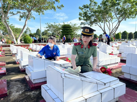 Tuổi trẻ Công an Kiên Giang: Lau chùi và thay hoa mới cho hơn 4.495 mộ phần liệt sĩ - Ảnh 2. Trân trọng dọn dẹp và lau chùi trên các phần mộ của anh hùng liệt sĩ - Ảnh: TRƯƠNG QUỐC