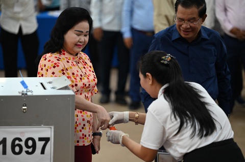 Đệ nhất phu nhân Bun Rany nhúng ngón tay vào lọ mực để làm dấu cho biết đã bỏ phiếu - Ảnh: AFP Bà Bun Rany (trái), phu nhân Thủ tướng Hun Sen, nhúng ngón tay vào lọ mực đánh dấu đã bỏ phiếu - Ảnh: AFP