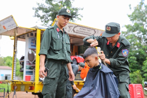 Ông Phan Đình Trạc thăm trung đoàn Cảnh sát cơ động Tây Nguyên - Ảnh 6. Các em nhỏ trên địa bàn Tây Nguyên được chiến sĩ cảnh sát cắt tóc miễn phí - Ảnh: NGUYỄN HẰNG