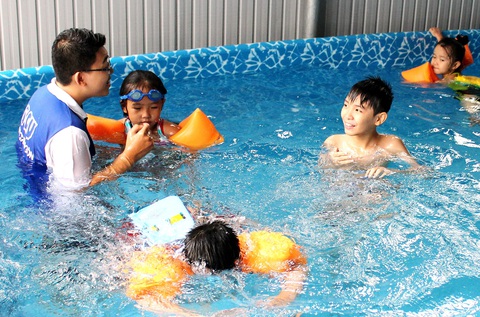 Cần cả kỹ năng cứu đuối nước an toàn - Ảnh 1. Sinh viên tình nguyện dạy bơi miễn phí cho trẻ tại TP.HCM mỗi dịp hè - Ảnh: Q.L.