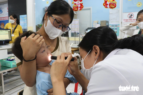 Tay chân miệng - Ảnh 6. Các bác sĩ đánh giá mức độ mắc bệnh tay chân miệng cho một bệnh nhi trước khi nhập viện - Ảnh: X.MAI