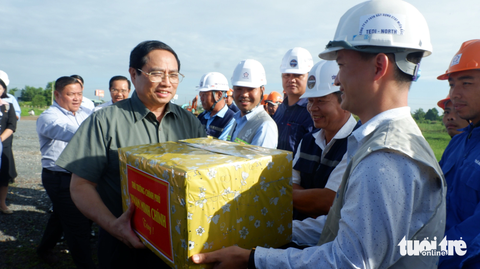 Kiểm tra đường Vành đai 3 TP.HCM, Thủ tướng nhắc 'hoàn thành càng sớm càng tốt' - Ảnh 1. Thủ tướng tặng quà cho các đơn vị thi công đường vành đai 3 TP.HCM qua Long An - Ảnh: SƠN LÂM