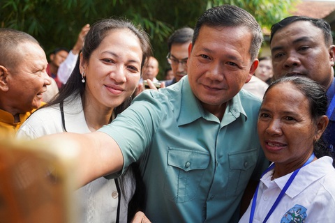 Bộ Ngoại giao nói về cuộc bầu cử ở Campuchia - Ảnh 2. Ông Hun Manet, con trai Thủ tướng Campuchia Hun Sen, chụp ảnh cùng cử tri sau khi đi bỏ phiếu ngày 23-7 - Ảnh: REUTERS