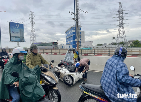 Nguy hiểm khi dừng xe khẩn cấp để mặc áo mưa - Ảnh 1. Ba xe máy tông liên tiếp trên cầu Sài Gòn - Ảnh: CHÂU TUẤN