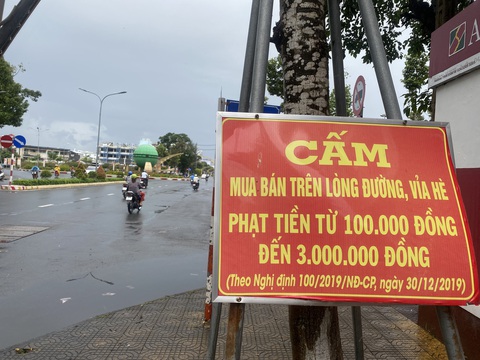 Tràn xuống đường bán vé số ở miền Tây - Ảnh 2. Trên đường Trần Hưng Đạo (phường 2, TP Sóc Trăng, tỉnh Sóc Trăng) có treo nhiều bảng cấm mua bán trên lòng đường, vỉa hè, ai vi phạm phạt tiền từ 100.000 - 3.000.000 đồng, nhưng hằng ngày có rất nhiều người bán vé số, hàng rong tụ tập mua bán tràn xuống lòng đường.