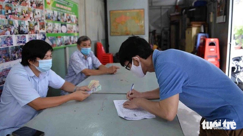 TP.HCM: Chính thức ban hành kế hoạch sắp xếp khu phố, ấp - Ảnh 1. Ban điều hành khu phố 3, phường 15, quận 10, TP.HCM hỗ trợ UBND phường chi trả tiền trợ cấp thất nghiệp bị ảnh hưởng trong đợt dịch COVID-19 - Ảnh: TỰ TRUNG