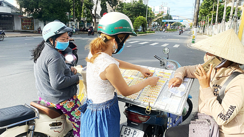 Chấm dứt hợp đồng với đại lý không nhận vé số ế - Ảnh 1. Người bán vé số dạo xuống lòng đường 3-2, phường An Bình, quận Ninh Kiều, TP Cần Thơ bán vé số - Ảnh: LÊ DÂN