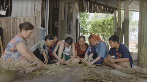 Hoa hậu Thuỳ Tiên lần đầu làm nông dân, “tuyệt vọng” vì quá vất vả - Ảnh 4. Qua được “ải” cắt cỏ bàng, hai “nong dân tập sự” lại nhiệt tình ngồi lại cùng các cô bác nhà cô Út Loan để học đan giỏ.