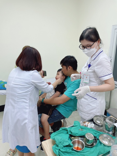 Các bác sĩ may vết thương cho cháu Minh Anh - Ảnh: Gia đình cung cấp Các bác sĩ khâu vết thương cho cháu Minh Anh sau khi cháu bị chó cắn - Ảnh: Gia đình cung cấp