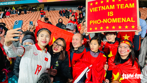 Bánh mì, phở Việt xôn xao World Cup nữ - Ảnh 1. Thanh Nhã chụp ảnh với các CĐV Việt Nam bên cạnh biểu ngữ cổ động có món phở sau trận gặp Bồ Đào Nha - Ảnh: TR.N.