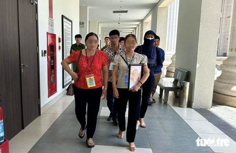 Bị kịch của những cô gái trẻ yêu nhầm kẻ 'cuồng ghen' - Ảnh 2. Gia đình của nạn nhân U.T.P. (20 tuổi, quê Lai Châu) ôm di ảnh con gái đến tòa - Ảnh: DANH TRỌNG
