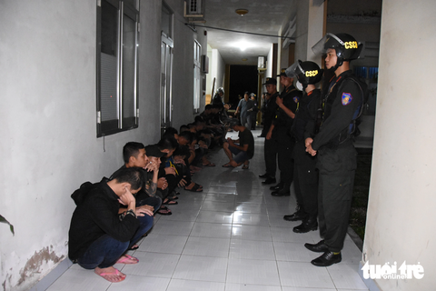 Vụ bắt 31 người mang súng đi đánh nhau là do mâu thuẫn trong chuyện tiền bạc - Ảnh 3. Các thanh niên bị bắt giữ tại cơ quan công an - Ảnh: QUANG LẬP