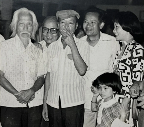 Nguyễn Sáng (thứ hai từ trái sang) và bà Đặng Thị Khuê (bìa phải) với tà áo dài duy nhất trong buổi khai mạc triển lãm của Nguyễn Sáng năm 1984 - Ảnh tư liệu Nguyễn Sáng (thứ hai từ trái sang) và bà Đặng Thị Khuê (bìa phải) với tà áo dài duy nhất trong buổi khai mạc triển lãm của Nguyễn Sáng năm 1984 - Ảnh tư liệu