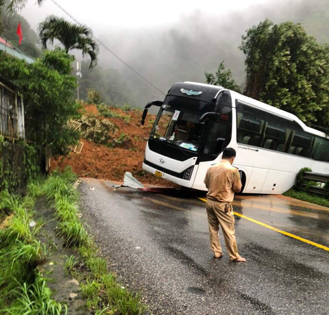 Đèo Bảo Lộc sạt lở đất, đè trạm cảnh sát giao thông, 3 chiến sĩ mất tích - Ảnh 2. Một xe khách đi ngang qua Trạm cảnh sát giao thông đèo Bảo Lộc bị đất đá đè - Ảnh: T.N.