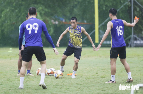 Đỗ Hùng Dũng: 'VAR khiến V-League bị kéo dài thì cũng bình thường như World Cup nữ' - Ảnh 3. Văn Quyết và các cầu thủ CLB Hà Nội tập luyện dưới trời mưa lớn tại Hà Nội - Ảnh: ĐỨC KHUÊ