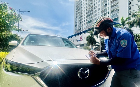 Thu phí đậu xe tại Vũng Tàu: Bước đầu thuận lợi nhưng ít xe dần - Ảnh 1. Nhân viên phường 7, TP Vũng Tàu viết biên lai thu phí đậu xe dưới lòng đường Nguyễn Thái Học - Ảnh: Đ.H.