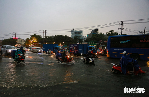 Quốc lộ 13 ngập lênh láng, hàng loạt xe máy dắt bộ trong cơn mưa - Ảnh 3. Đến 19h cùng ngày, tình trạng ngập nước trên quốc lộ 13 vẫn chưa có dấu hiệu giảm - Ảnh: CHÂU TUẤN