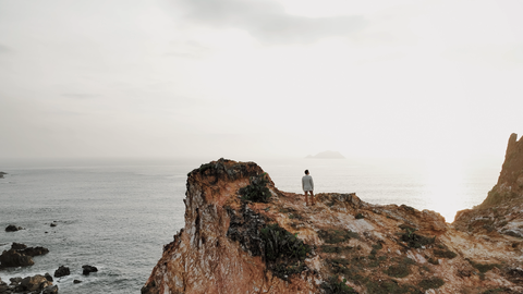 Quang Dũng mời hoa hậu Mai Phương về thăm quê hương Quy Nhơn - Ảnh 2. Quang Dũng trong cảnh quay tại Eo Gió, một địa danh hoang sơ và kỳ vĩ tiêu biểu cho vẻ đẹp thiên nhiên của vùng đất Quy Nhơn