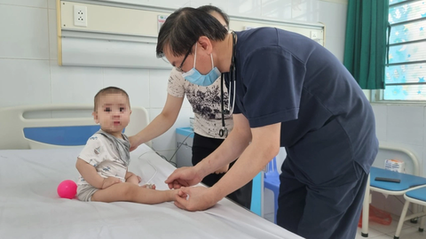 Tin tức sáng 7-7: Đề xuất thành lập Đại học Thống kê; Kéo dài niên hạn sử dụng phương tiện đường sắt - Ảnh 1. Bác sĩ Bệnh viện Nhi trung ương thăm khám cho trẻ mắc tay chân miệng - Ảnh: DƯƠNG LIỄU