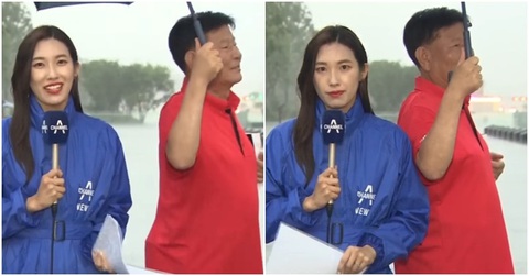 Ông chú qua đường che ô cho nữ phóng viên đang đưa tin dưới mưa - Ảnh 1. Ông chú qua đường tốt bụng che ô cho nữ phóng viên tránh mưa.