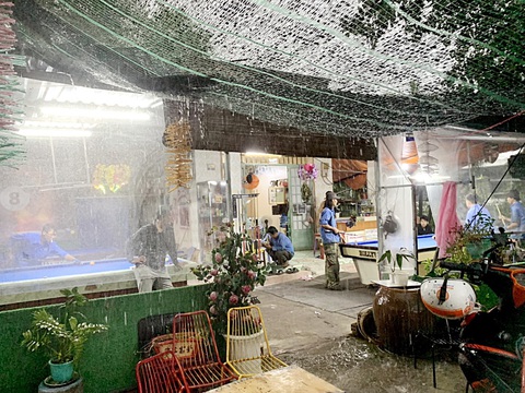 Bãi rác Đa Phước: Mùi hôi lại tấn công đô thị - Ảnh 5. Anh Quang, chủ quán cà phê bida võng, cho biết phải căng tấm nilông đễ giảm bụi và tiếng ồn khi xe ra vào khu vực lấy rác Đa Phước (ấp 1, xã Đa Phước, huyện Bình Chánh, TP.HCM) - Ảnh: T.T.D.