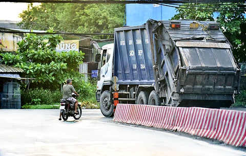 Bãi rác Đa Phước: Mùi hôi lại tấn công đô thị - Ảnh 4. Xe lấy rác đi ngang qua khu dân cư trên quốc lộ 50, xã Đa Phước, huyện Bình Chánh - Ảnh: T.T.D.