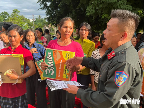 Thượng tá Nguyễn Công Hòa, trưởng công an huyện Ea Hleo trao quà, thu vũ khí từ người dân - Ảnh: M.P. Thượng tá Nguyễn Công Hòa, trưởng Công an huyện Ea Hleo, trao quà và nhận vũ khí từ người dân - Ảnh: M.P.
