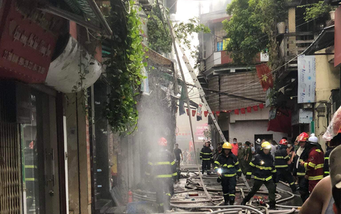 Cháy nhà dân ở Hà Nội, 3 người mắc kẹt bên trong - Ảnh 3. Cảnh sát tiến hành dập lửa - Ảnh: MINH QUANG
