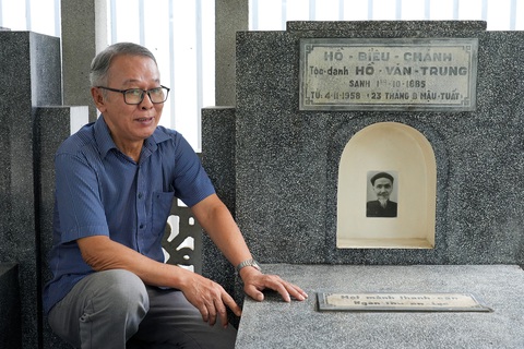 Một buổi sáng ghé thăm An Tất Viên - nơi an nghỉ của cụ Hồ Biểu Chánh - Ảnh 2. Ông Trần Quốc Oai, chắt của cụ Hồ Biểu Chánh, bên bia mộ của cụ cố. Trên bia có ghi danh sách những tác phẩm nổi bật của cụ khi còn sống và câu đối về cuộc đời cụ.