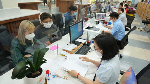 Đề xuất bổ sung quy định đánh giá, xếp loại chất lượng cán bộ - Ảnh 1. Các chuyên viên UBND quận Tân Phú (TP.HCM) giải quyết hồ sơ cho người dân - Ảnh: HỮU HẠNH